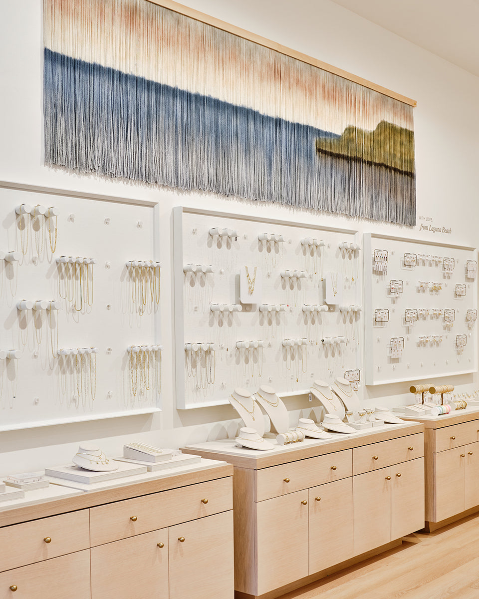 gorjana store with white walls and necklaces on pegs