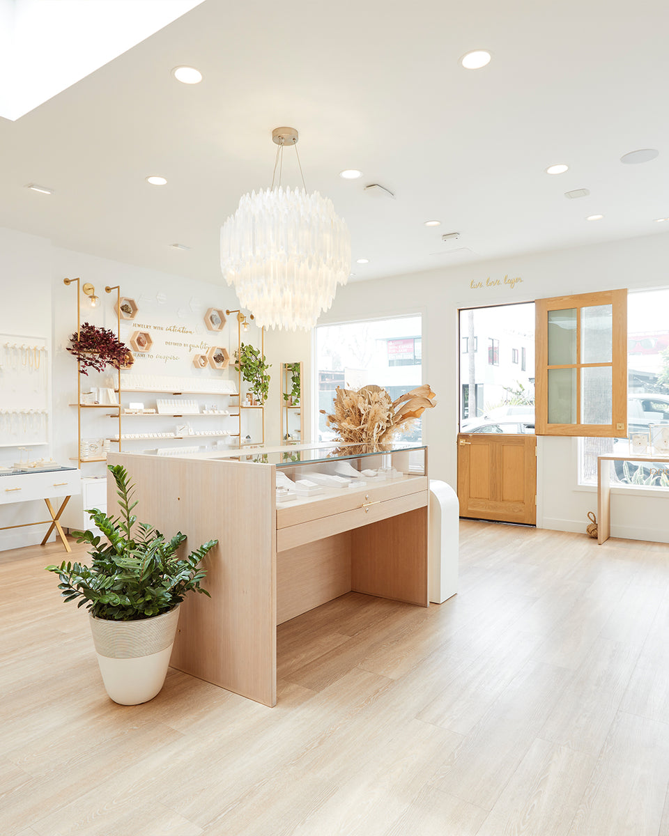 gorjana store with fine jewelry case in the middle of it with green plants